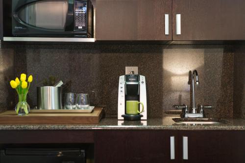 a coffee maker on a kitchen counter next to a sink at Glover Park Hotel Georgetown in Washington, D.C.