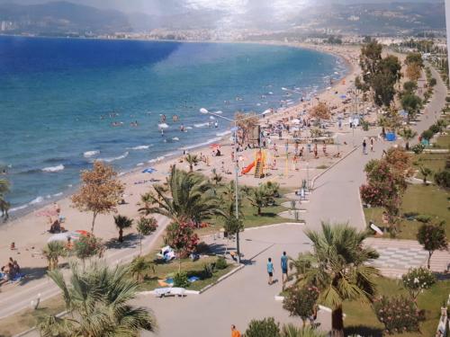 a beach with a crowd of people and the ocean at Samos Apart Pension in Güzelçamlı