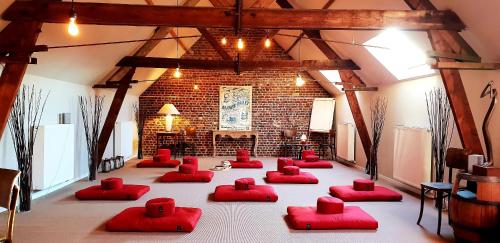 um quarto com cadeiras vermelhas num quarto com uma parede de tijolos em R&breakfast em Roeselare
