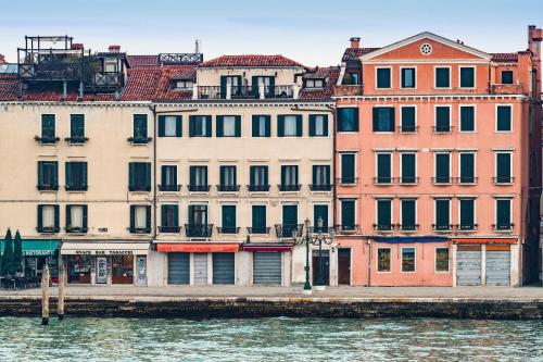 um grupo de edifícios ao lado de uma massa de água em A Tribute To Music Residenza em Veneza