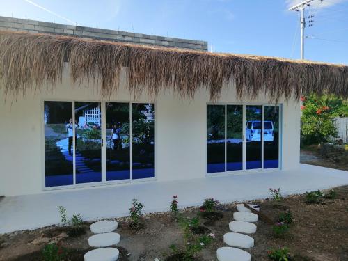 a white building with a thatched roof at Eastern Garan Hen Yuan Resort in Siquijor