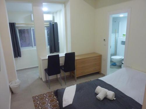 - une chambre avec un lit et un bureau avec deux chaises dans l'établissement Allenby2, à Jérusalem