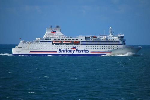 a large cruise ship on the water at Joli studio au calme dans un jardin privatif in Ouistreham