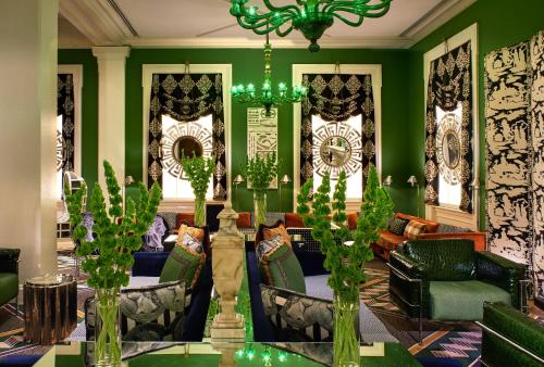 a living room with green walls and a chandelier at Kimpton Hotel Monaco Washington DC, an IHG Hotel in Washington, D.C.