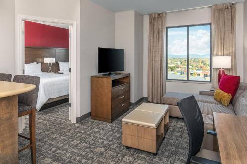 a hotel room with a bed and a tv at Staybridge Suites Charlottesville Airport by IHG in Charlottesville