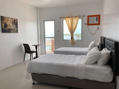 um quarto com 2 camas e uma janela em Arriyus Apartelle em Maya