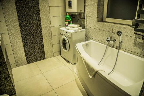 a bathroom with a washing machine and a washer at Apartamenty KORONA in Krosno