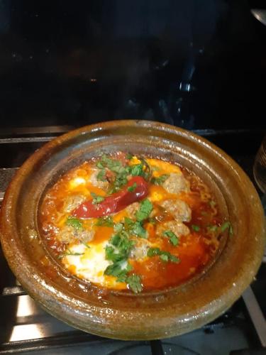 a brown bowl of food in an oven at Riad TANJIL in Casablanca