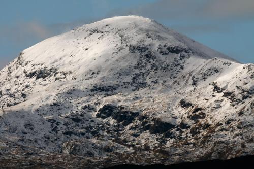a mountain covered in snow on top of it at Cairngorm Bothies in Aboyne