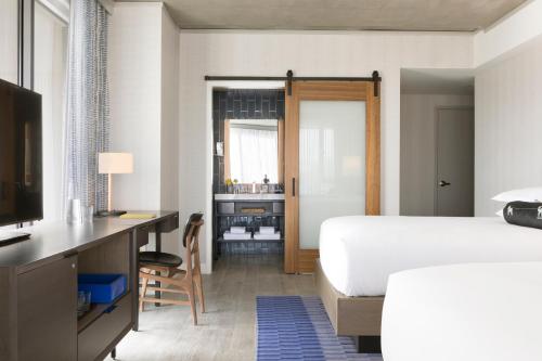 a bedroom with a bed and a desk with a computer at Kimpton Rowan Palm Springs Hotel by IHG in Palm Springs