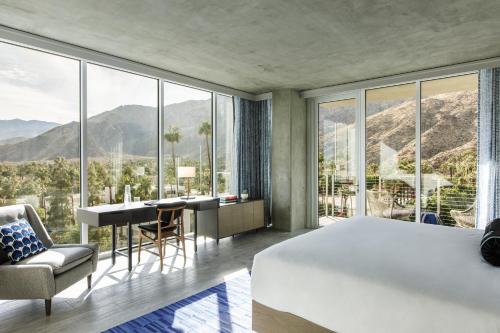a bedroom with a bed and a desk with a view at Kimpton Rowan Palm Springs Hotel by IHG in Palm Springs