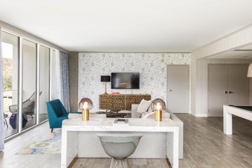 a living room with a white table and a couch at Kimpton Rowan Palm Springs Hotel by IHG in Palm Springs