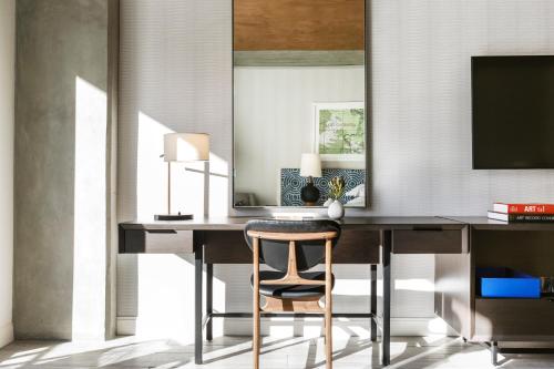 a desk with a chair and a mirror at Kimpton Rowan Palm Springs Hotel by IHG in Palm Springs