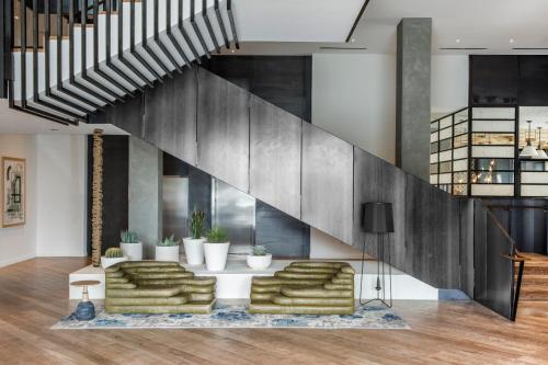 a living room with a couch and a staircase at Kimpton Rowan Palm Springs Hotel, an IHG Hotel in Palm Springs