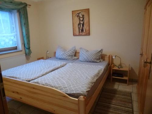 1 dormitorio con cama de madera en una habitación en Ferienwohnung Kirchblick, en Heyweiler