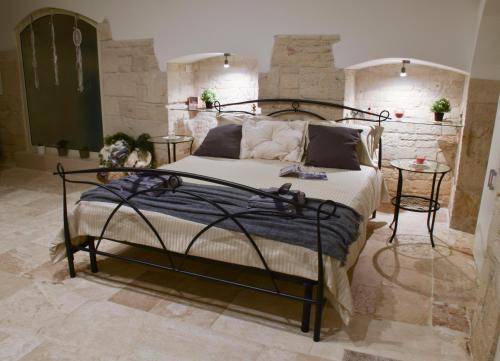 a bedroom with a wrought iron bed and two tables at B&B borgo del capitolo in Santeramo in Colle