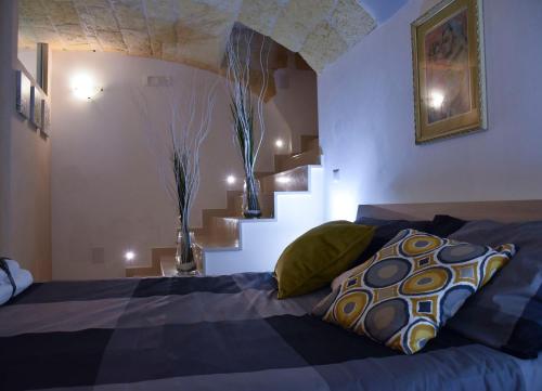 a bedroom with a bed with two vases on the wall at B&B borgo del capitolo in Santeramo in Colle