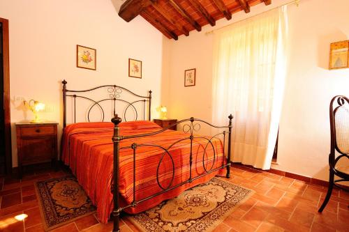 a bedroom with a bed with an orange bedspread at Agriturismo Il Torrino in Cortona