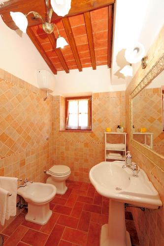 a bathroom with two sinks and a toilet and a mirror at Agriturismo Il Torrino in Cortona