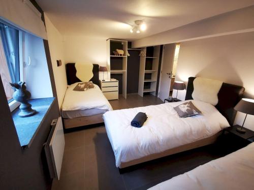 a bedroom with two beds and a mirror at L'Atelier in Houyet
