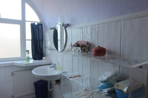 a white bathroom with a sink and a mirror at Appartment Julia in Lötzbeuren