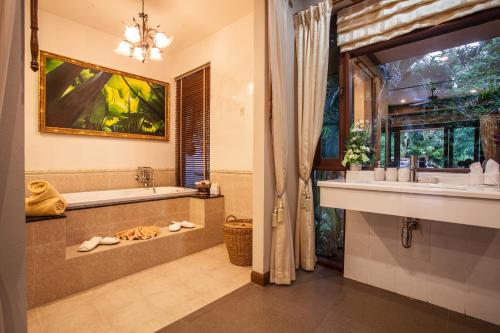 y baño con bañera, lavabo y espejo. en Saifon Villas 3 Bedroom Pool Villa can also be rented as a 2 bedroom or 1 bedroom villa en Ao Nang Beach