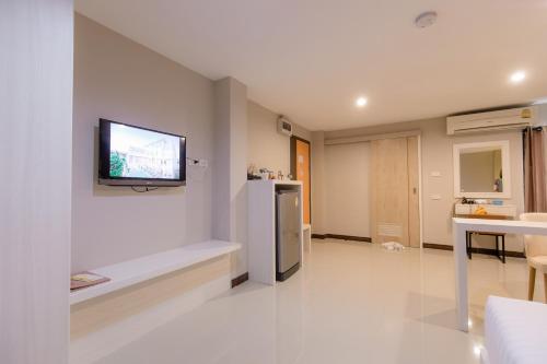 Una televisión o centro de entretenimiento en De Hug Hotel & Residence