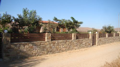 a stone retaining wall next to a dirt road at Caviro on the Beach in Moudhros