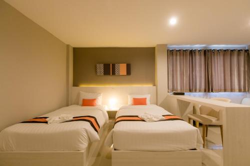 Una cama o camas en una habitación de De Hug Hotel & Residence