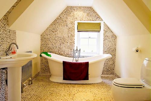 baño con bañera grande y lavamanos en The Head Gardeners Cottage, Dunbar, en Dunbar