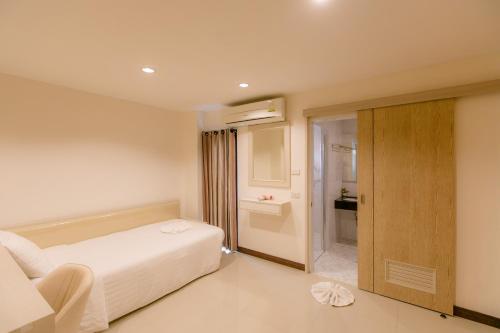 Una cama o camas en una habitación de De Hug Hotel & Residence