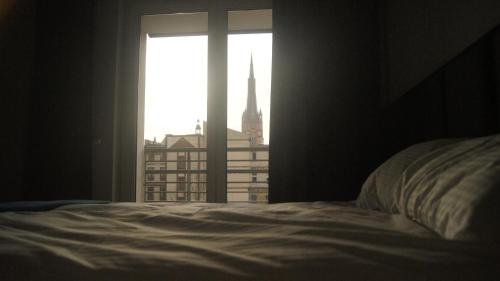 sypialnia z łóżkiem i oknem z widokiem w obiekcie Art Apartment Szczecin II w Szczecinie