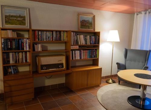 a living room with book shelves filled with books at Hotell Toppen in Storuman
