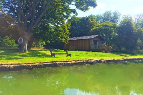 a bench sitting in front of a building next to a lake at The Lodge by the Lake, Dunbar in Dunbar