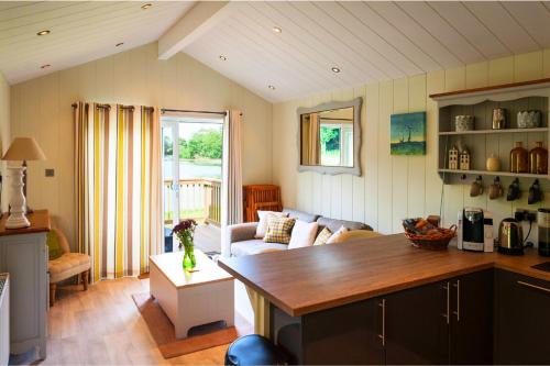 eine Küche und ein Wohnzimmer mit einem Sofa und einem Tisch in der Unterkunft The Lodge by the Lake, Dunbar in Dunbar