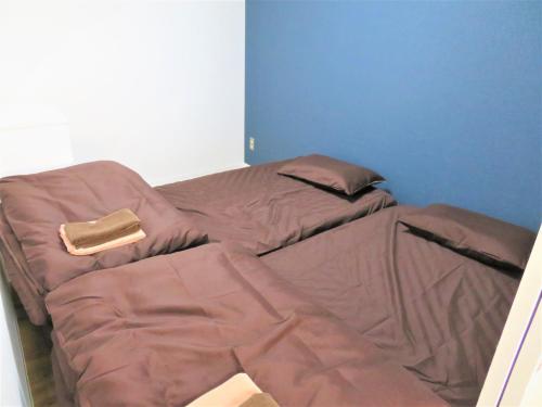 two beds sitting next to each other in a room at 札幌市中心部大通公園まで徒歩十分観光移動に便利なロケーションh507 in Sapporo