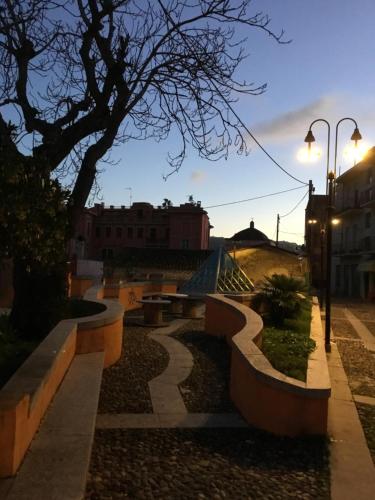 a park with benches and a tree at dusk at La Casa di Marco in Nuoro