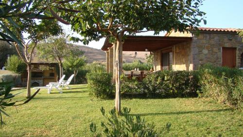 a house with a table and chairs in a yard at Caviro on the Beach in Moudhros