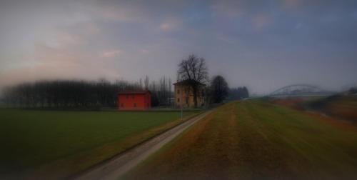 a dirt road with a house in the middle of a field at B&B L'Alberone in Budrio