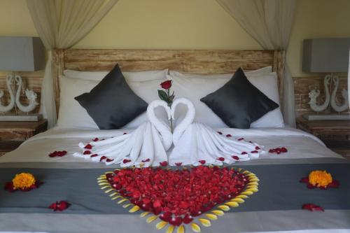 a bed with a heart made out of red roses at Villa D'Uma in Ubud