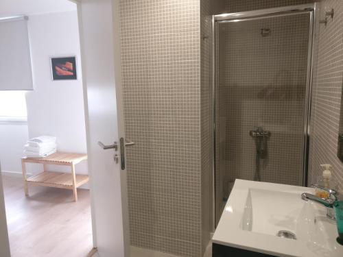 a bathroom with a shower and a white sink at Casa Irene in Aveiro