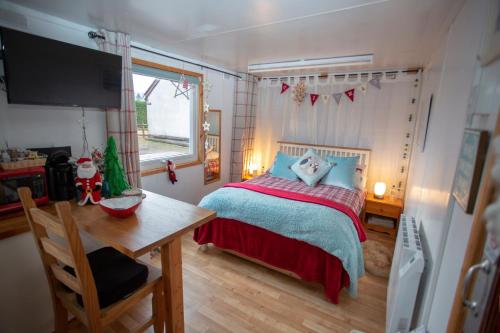 a bedroom with a bed and a table and a window at Room with a view in Spean Bridge