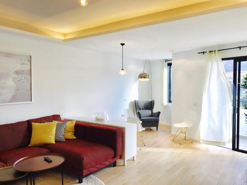 a living room with a red couch and yellow pillows at Hauzify I Apartamento Ruiz de Padron in San Sebastián de la Gomera