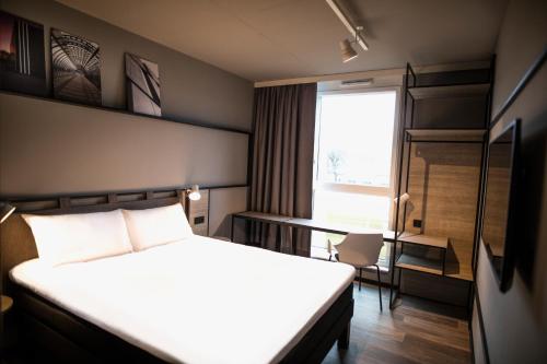 a hotel room with a bed and a window at ibis Wels in Wels