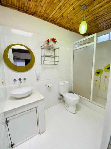 a bathroom with a toilet and a sink and a mirror at Zurisadai in Puerto Ayora