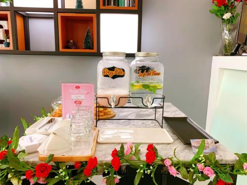 a counter with two glass jars on a table with flowers at The Connex Asoke in Bangkok