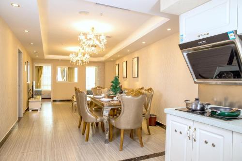 una cucina e una sala da pranzo con tavolo e sedie di Guangzhou Pengman Apartment Zhengjia Huanshi Branch a Canton
