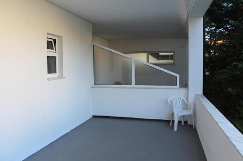a white house with a white chair on a balcony at Hotel Minho Belo in Vila Nova de Cerveira