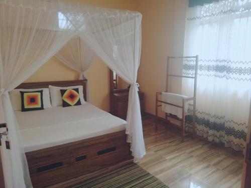 1 dormitorio con cama con dosel y silla en Nisadi Villa, en Bentota