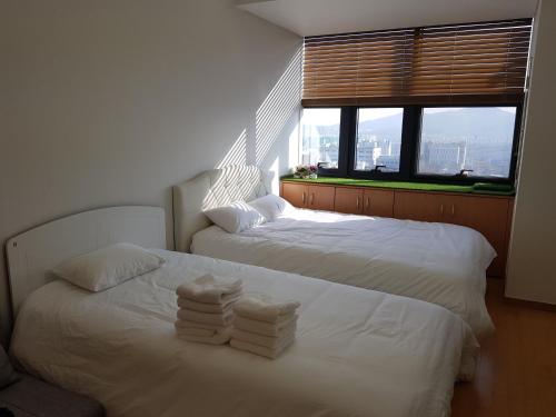 two white beds in a room with a window at Samseong Coexmall S in Seoul